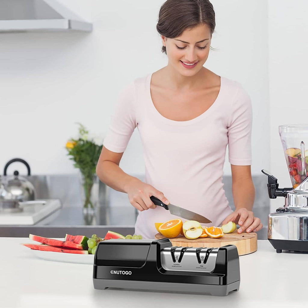 ENUTOGO electric knife sharpener on countertop as a person sharpens a knife