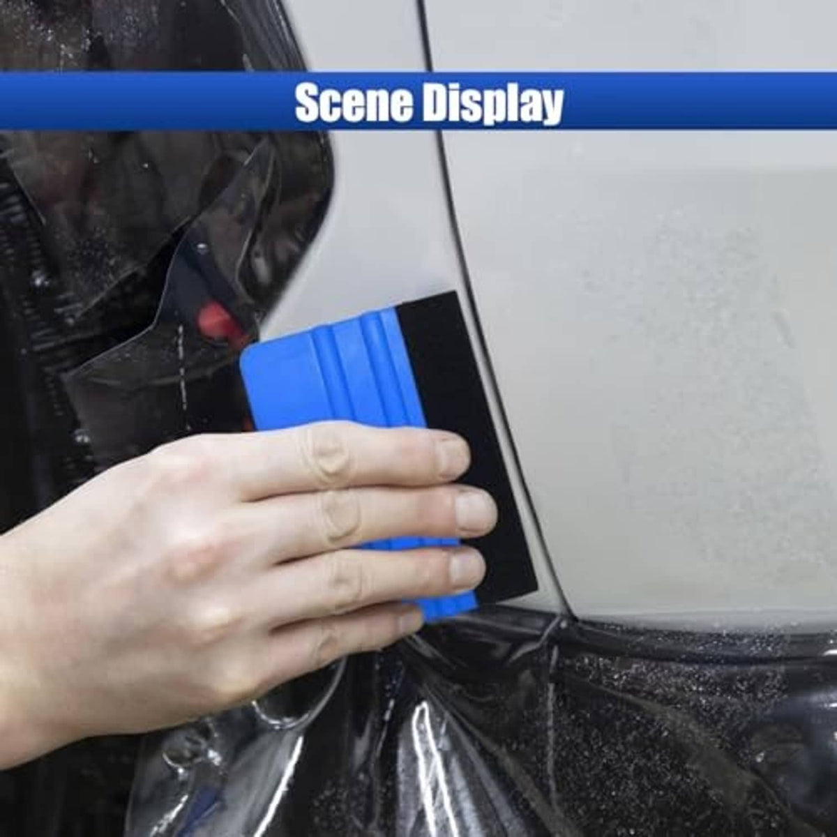 Handheld blue plastic scraper with black felt edge for applying film smoothly