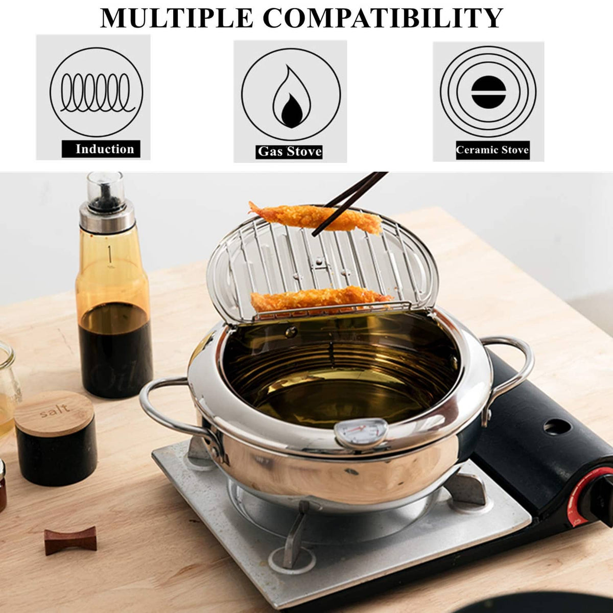 Stainless steel deep-fryer pot on a stovetop, wire basket holding fried chicken