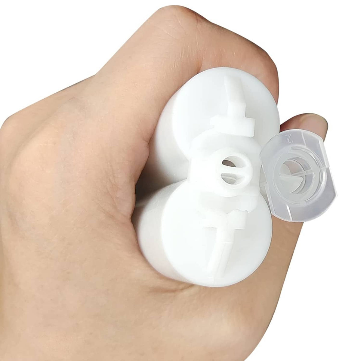Clear static mixer nozzle tip with internal mixing core, close-up held in hand