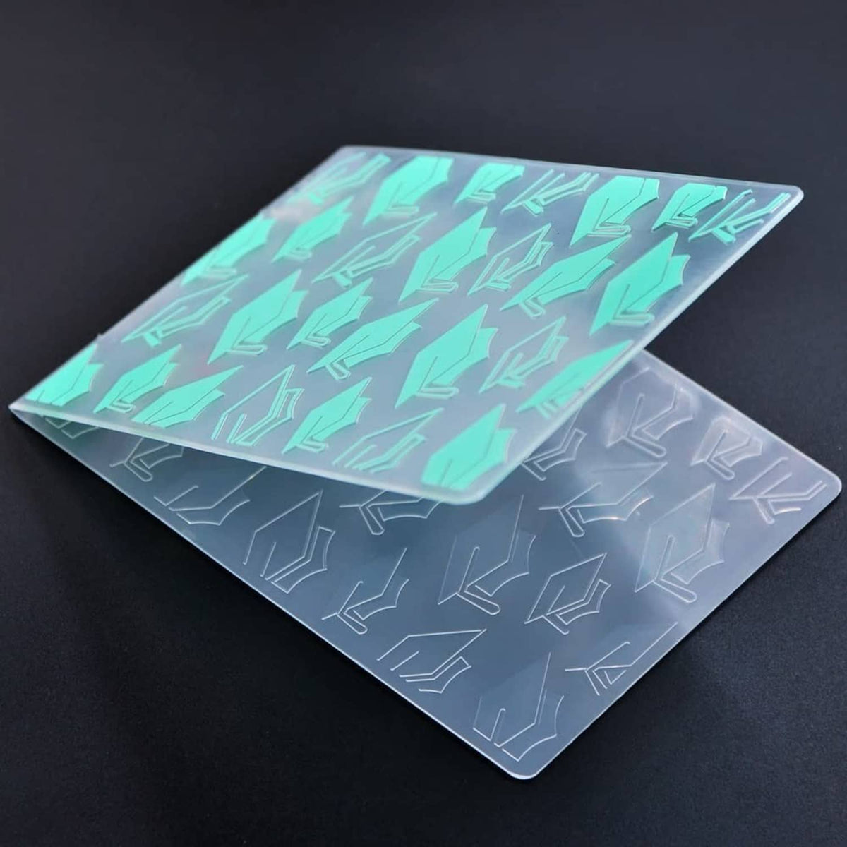 Plastic embossing folders with graduation cap patterns in mint and gray