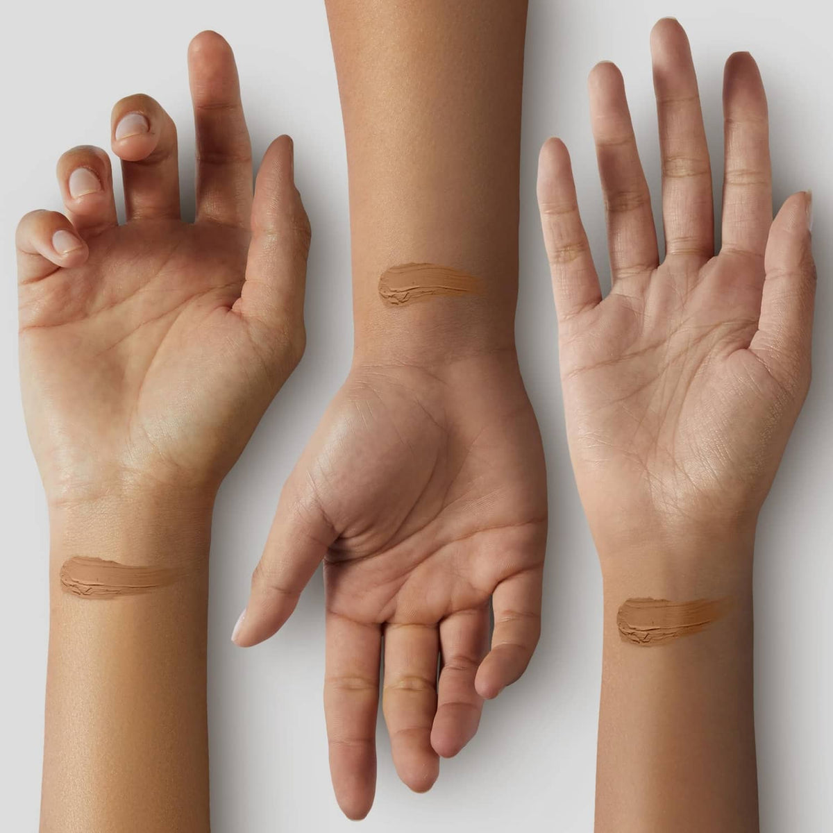 Cool tan concealer on hands and arms, showing smooth shade swatches