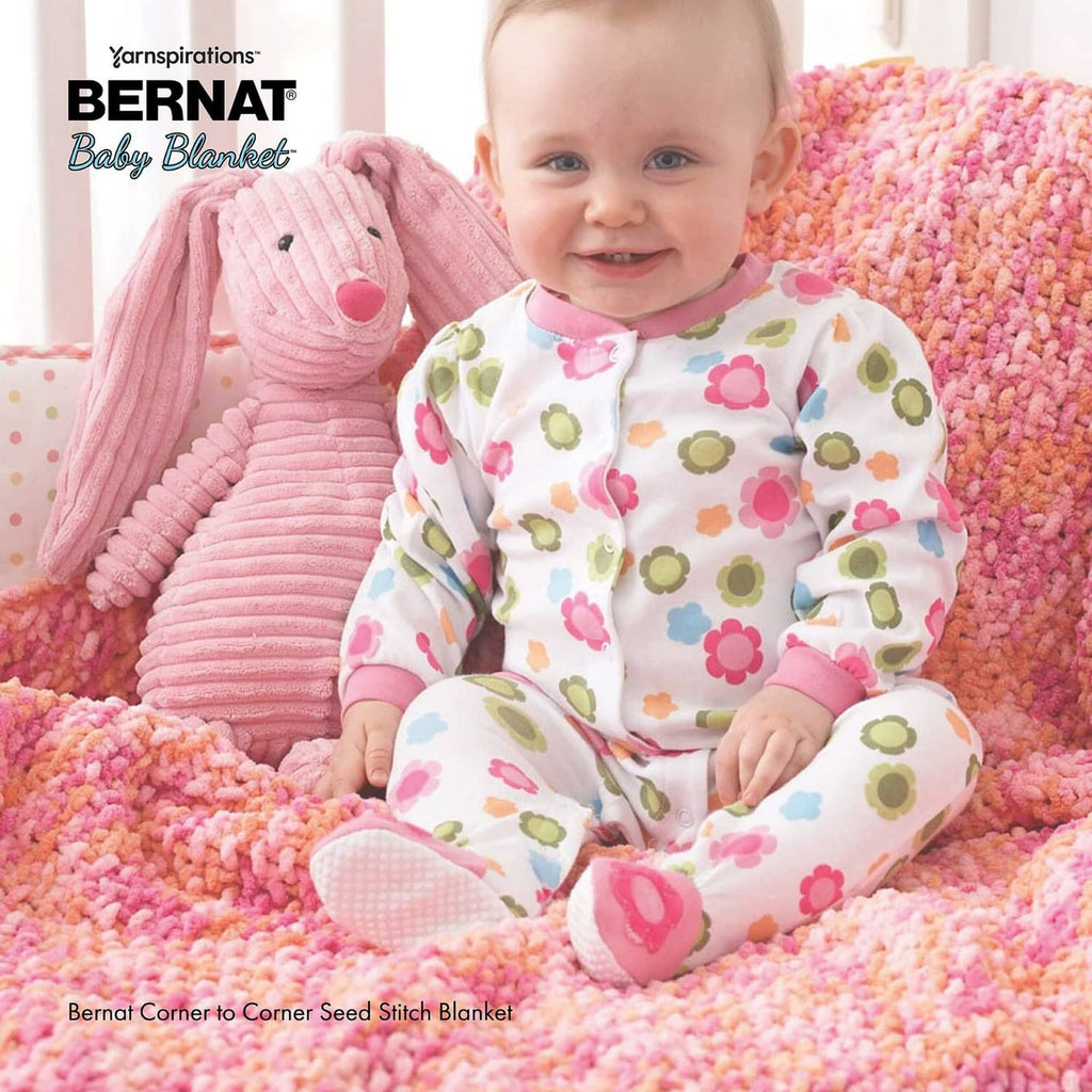 Pink knit baby blanket with raised pattern and plush border