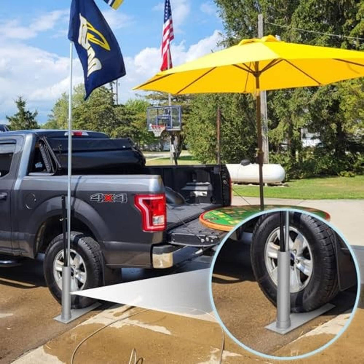 Portable tire-mount flag pole base with silver pole on truck bed near wheels
