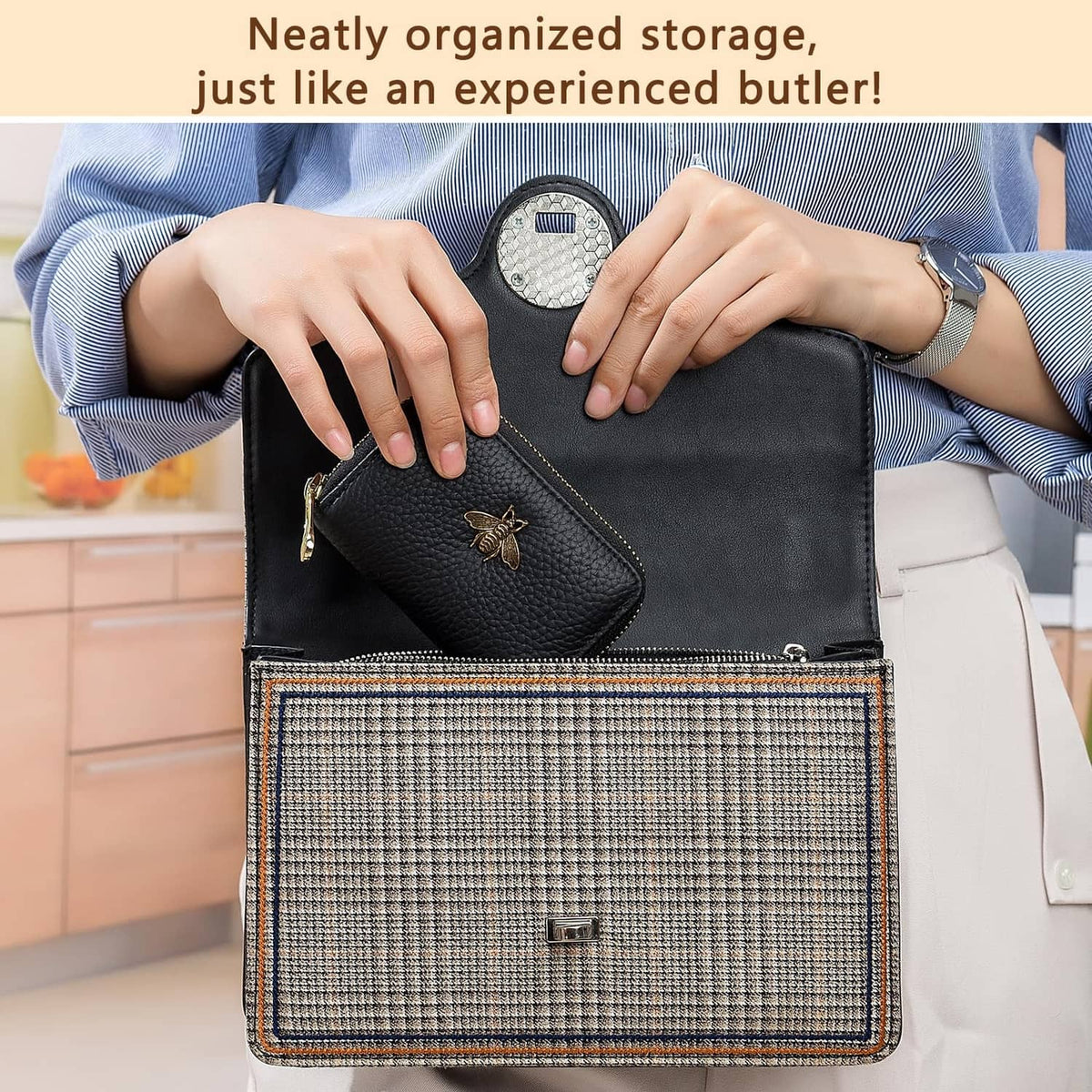 Black leather zipper card wallet with gold bee charm, held in hand