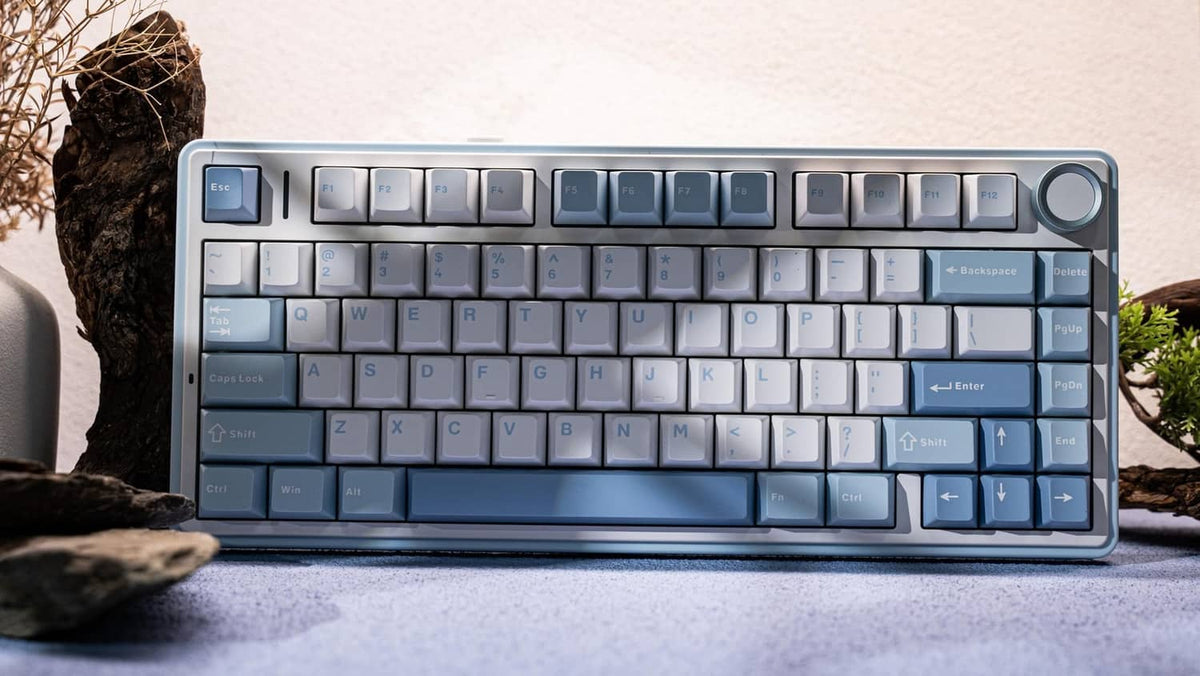 Sea salt blue mechanical keyboard with white and blue keycaps on a stone surface