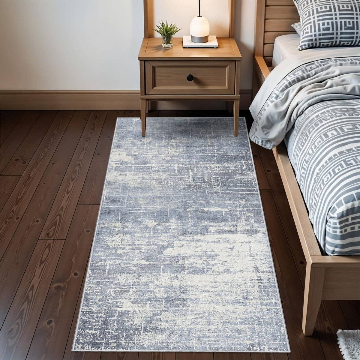 Rectangular blue and ivory runner rug with distressed pattern in a bedroom hallway.