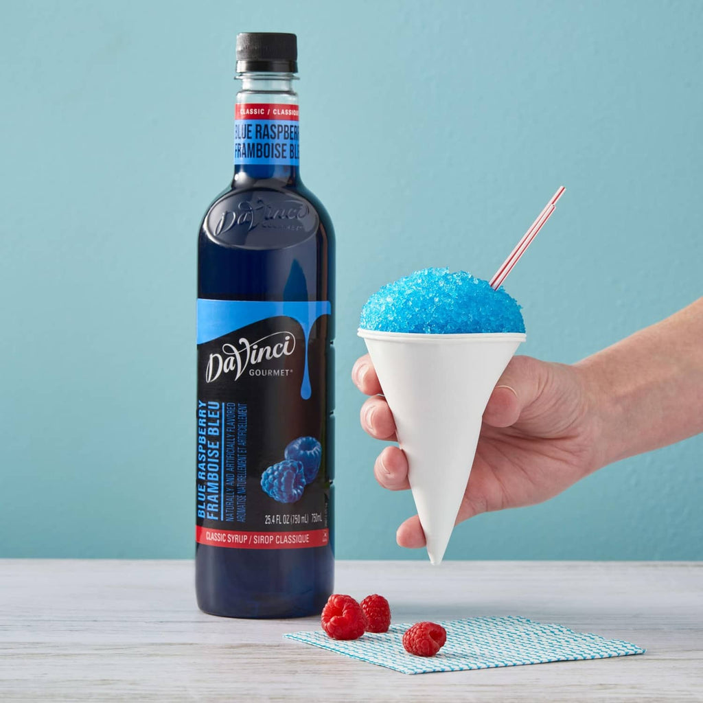 DaVinci Gourmet blue raspberry syrup bottle with hand holding blue slush cone