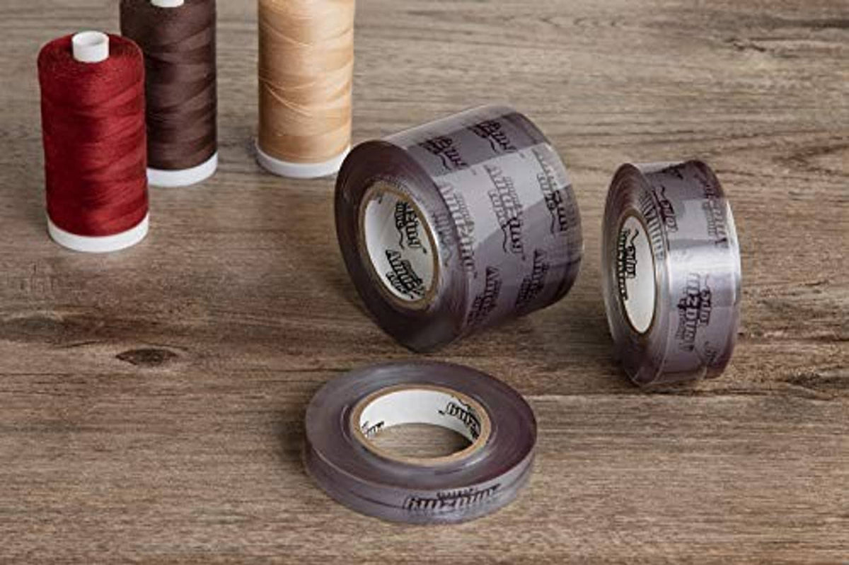 Three purple non-adhesive stretch-wrap tape rolls with exposed white cores