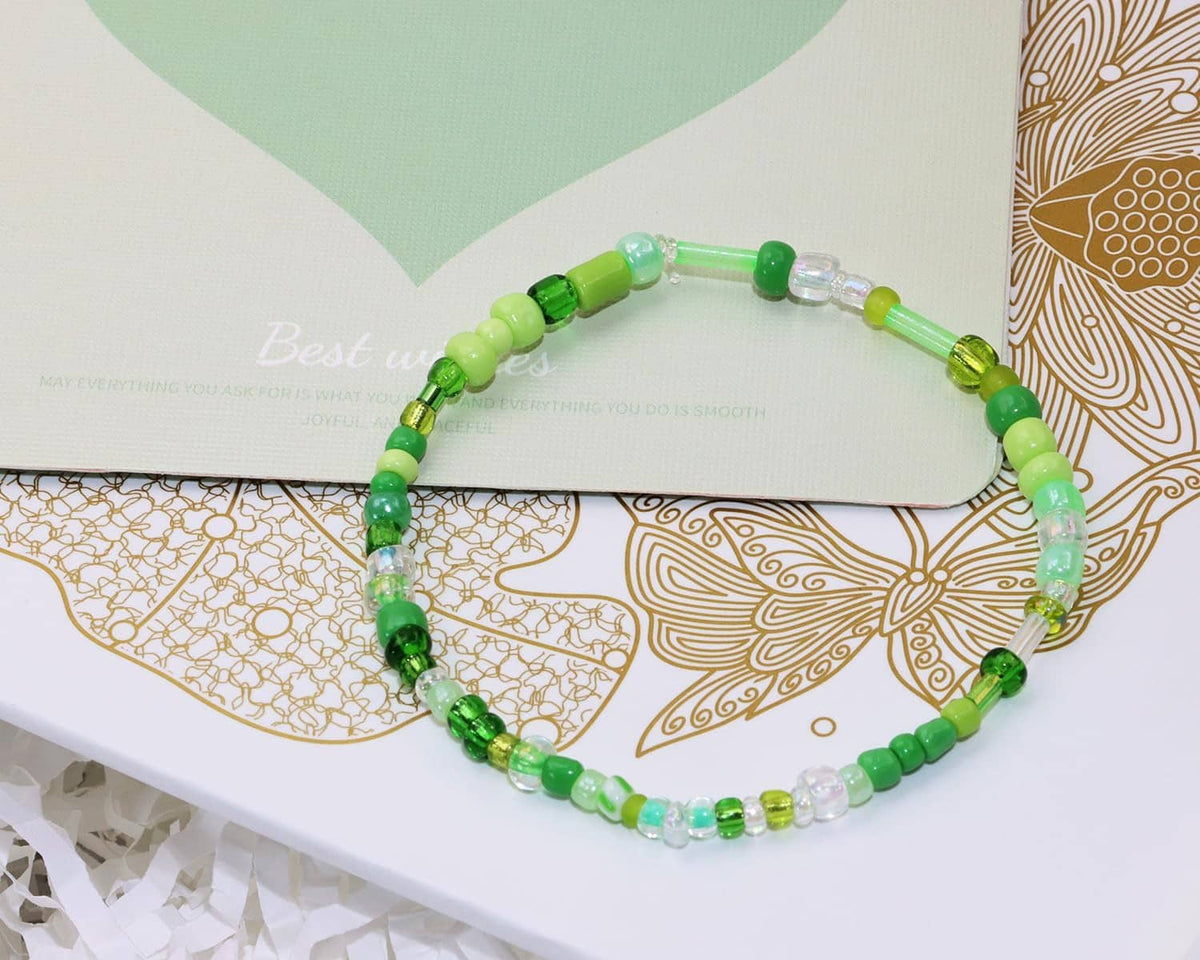 Green beaded bracelet with round and tube seed beads on an elastic string