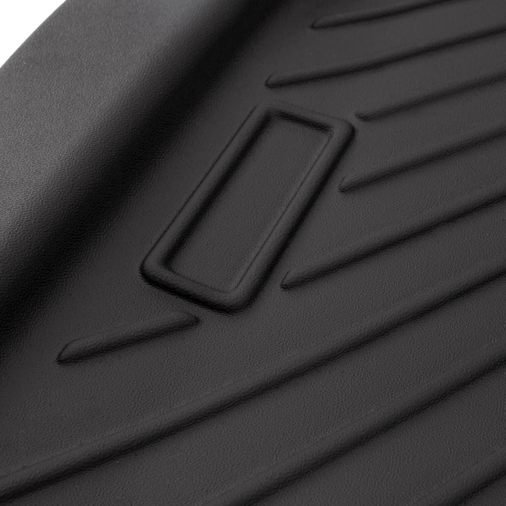 Close-up of black TPE floor mat with molded traction ribs and recessed square pad