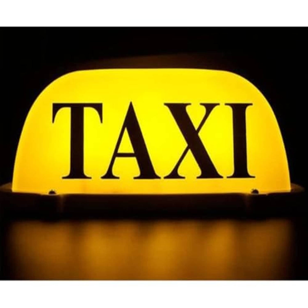 Illuminated yellow TAXI dome LED car sign light with dark base glowing at night