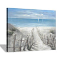 Coastal ocean canvas print with sandy path, fences, and sailboats over calm blue water