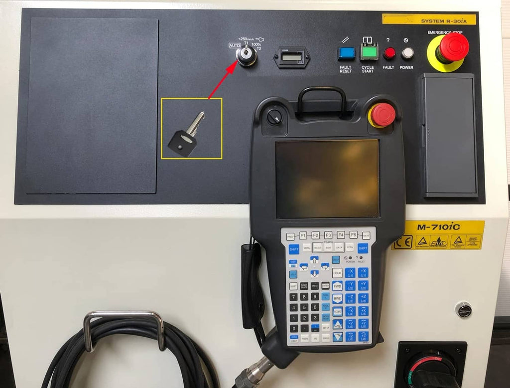 Robot control teach pendant with screen and buttons on industrial cabinet panel