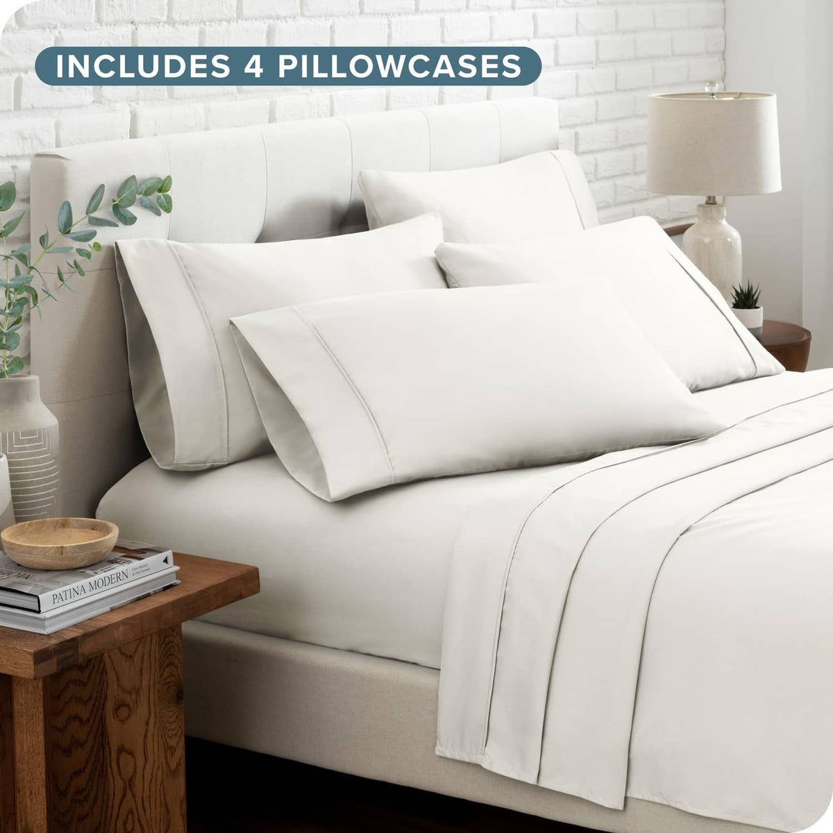 Cream microfiber bed linen set with four pillowcases and layered sheets on bed