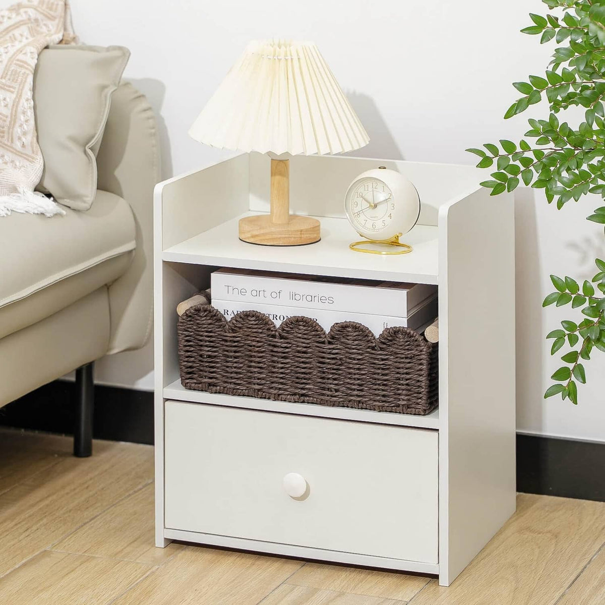 Brown woven toilet paper storage basket with scalloped front inside a white cabinet