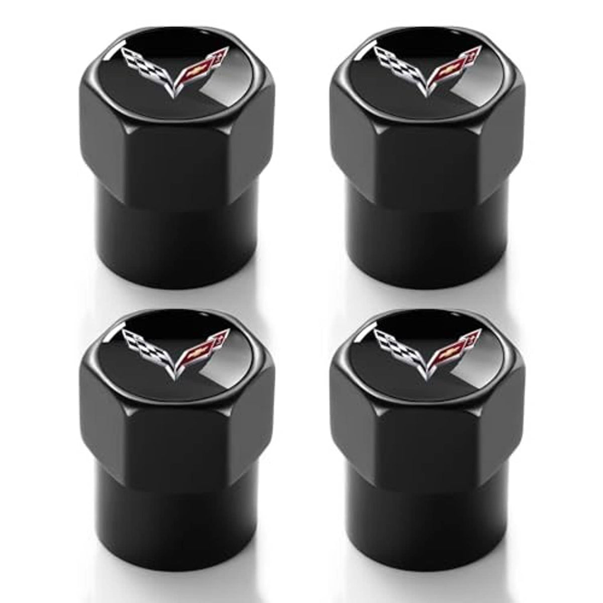 Four black valve stem caps with Corvette logo, metal finish, angled view.