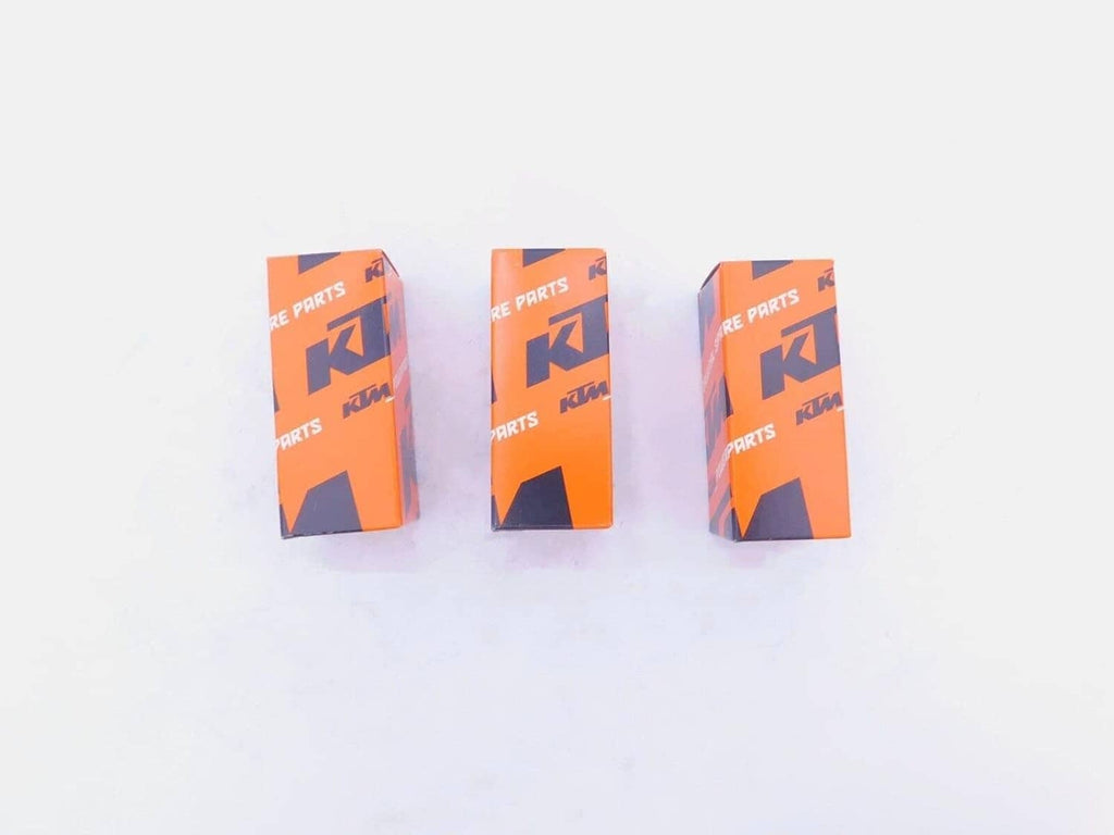 Three KTM oil filter boxes, orange with black graphics and branding