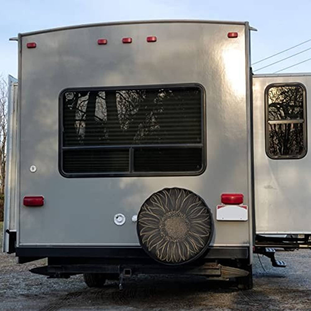 Black spare tire cover with gold sunflower floral design on rear of camper
