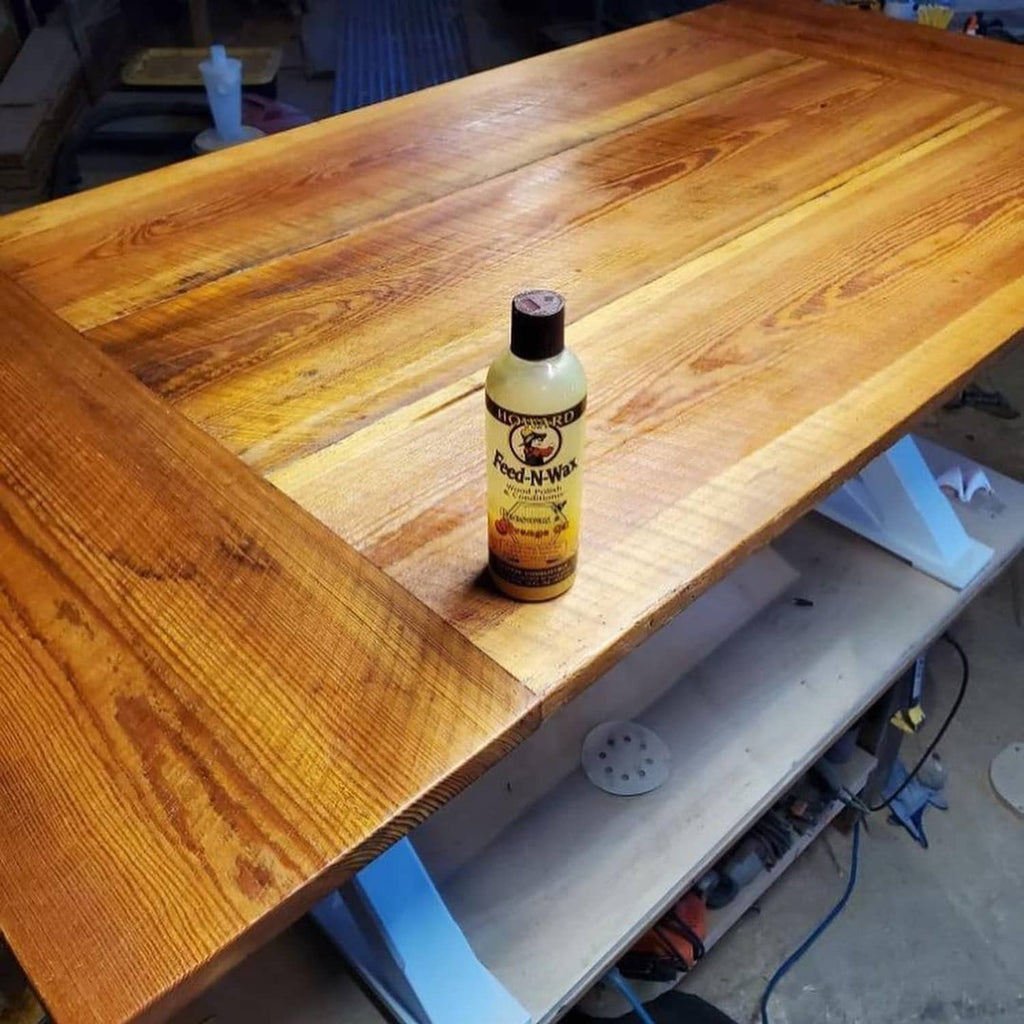 Howard Feed-N-Wax wood polish bottle on a wooden workbench
