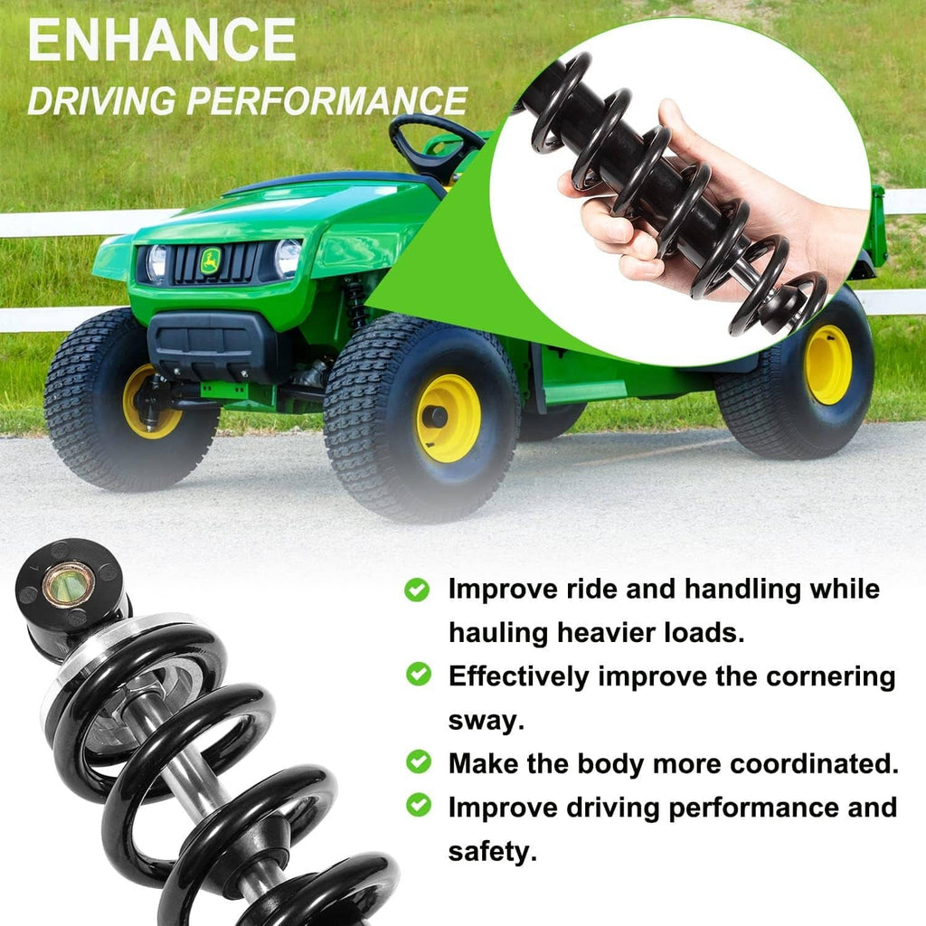 Front shock absorber in hand with black coil spring beside green utility vehicle