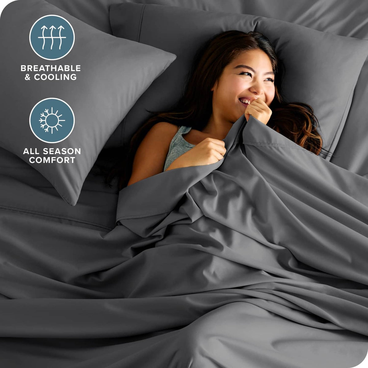 Grey bedding set with soft-looking sheet and pillowcases on bed in close-up