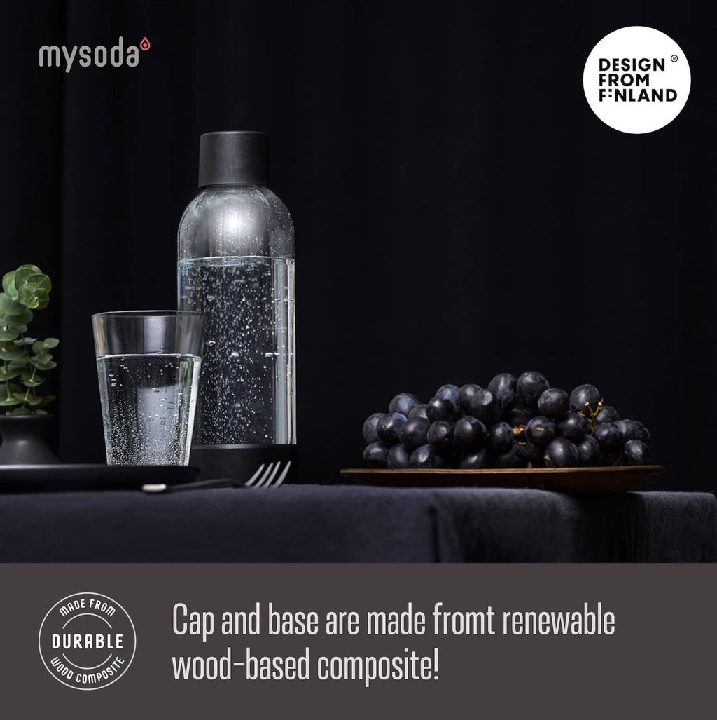Mysoda carbonating bottle with black cap and speckled surface, with glass nearby