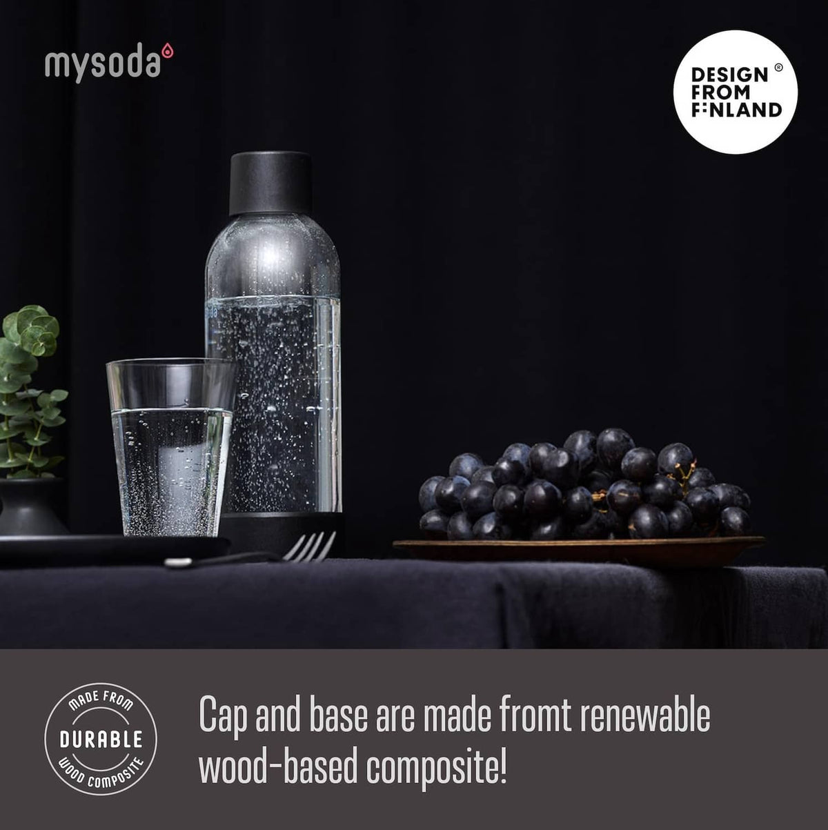 Mysoda carbonating bottle with black cap and speckled surface, with glass nearby