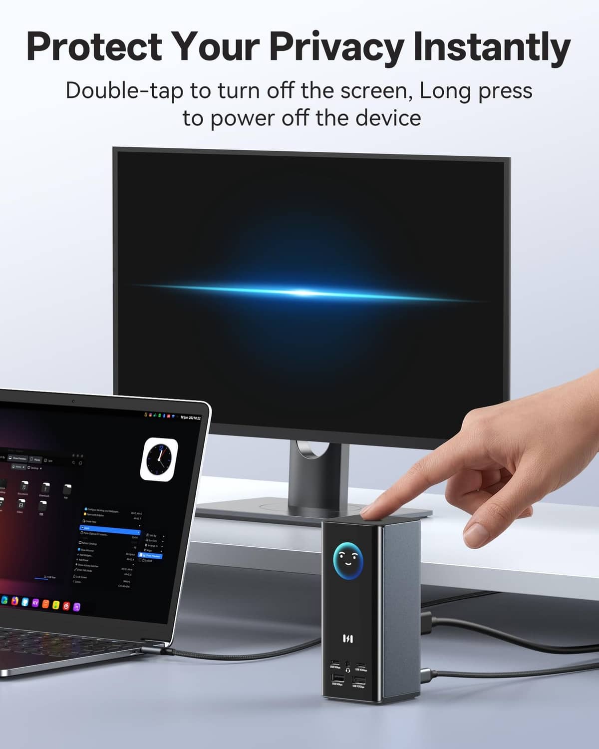 Space gray laptop docking station with front USB ports, hand plugging in a cable