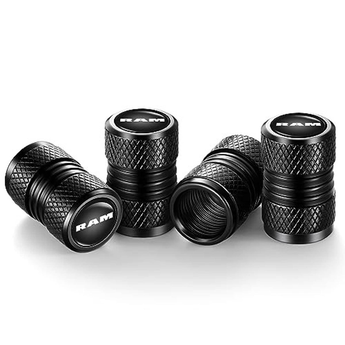 Four black RAM tire valve stem caps with knurled grip, ribbed sides, logo caps