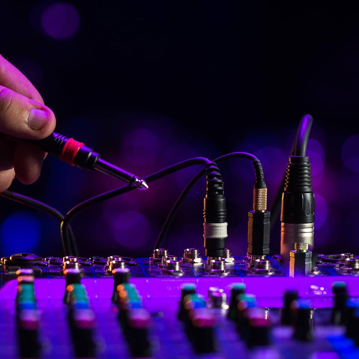 4-pin XLR female connector plugged into an audio cable near a mixer