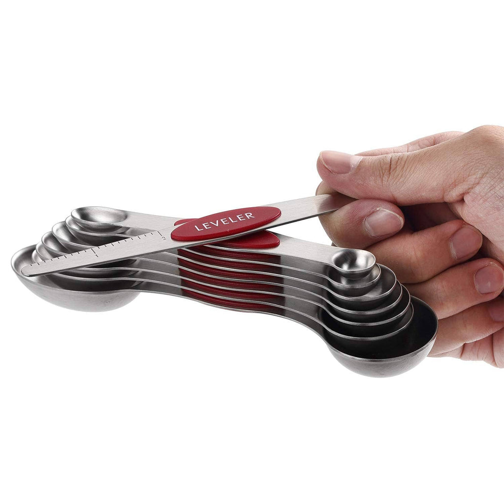 Hand holding nested magnetic measuring cups with a red Leveler spoon; stainless set