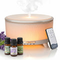 White essential oil diffuser with warm LED light top and included essential oil bottles.