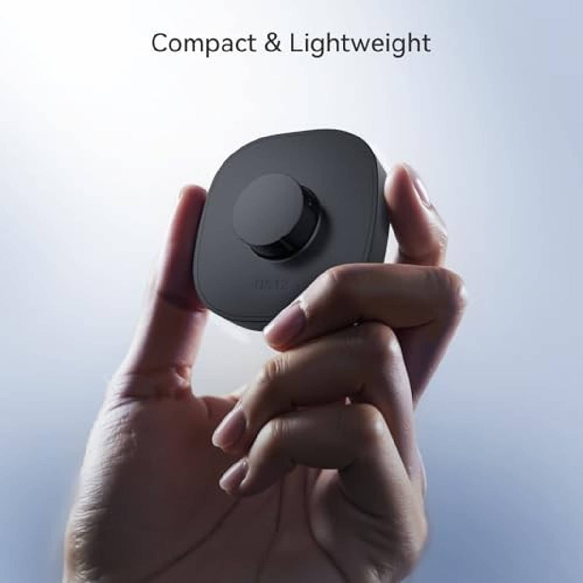 Compact lightweight ring charger held in hands, black charging dock