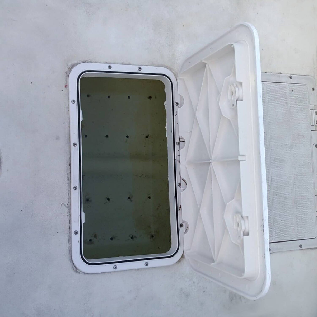 White boat deck hatch installed with lid open showing interior compartment