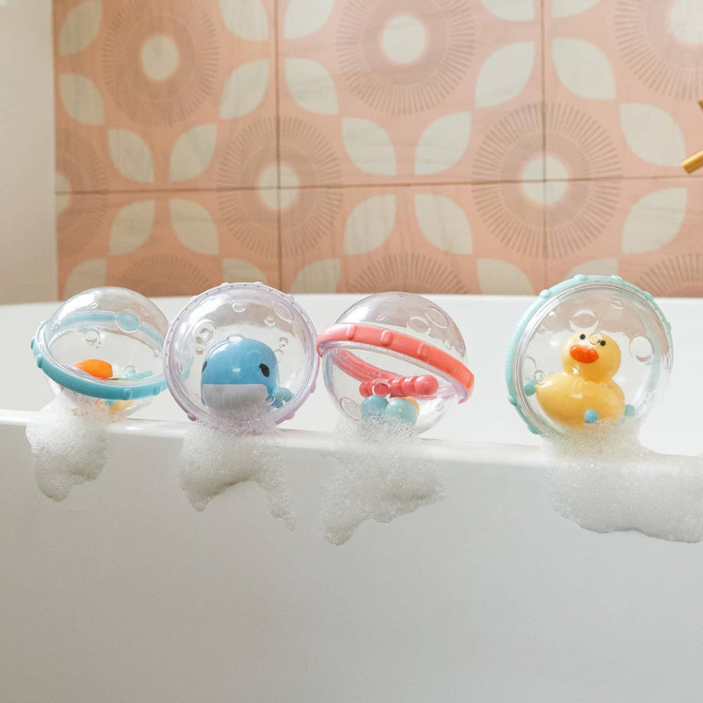 Clear bubble float bath toys floating in soapy water, showing duck, whale, fish, and star