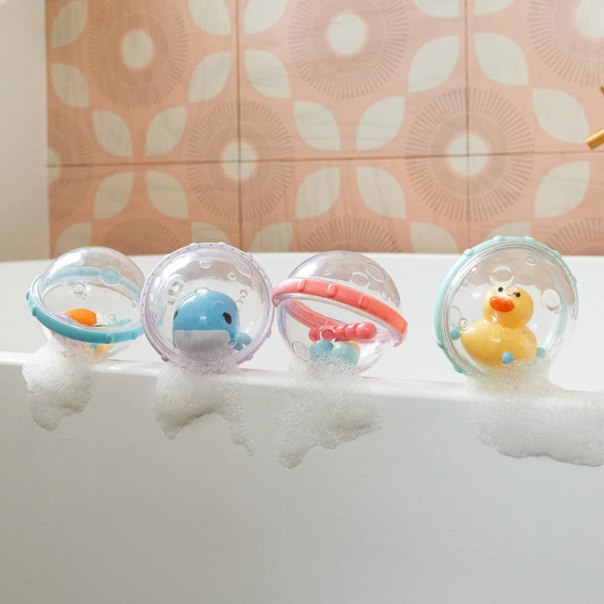 Clear bubble float bath toys floating in soapy water, showing duck, whale, fish, and star