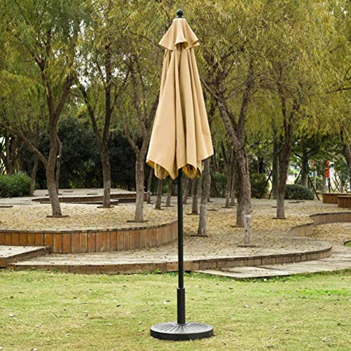 Tan outdoor patio umbrella with black pole and wide open canopy