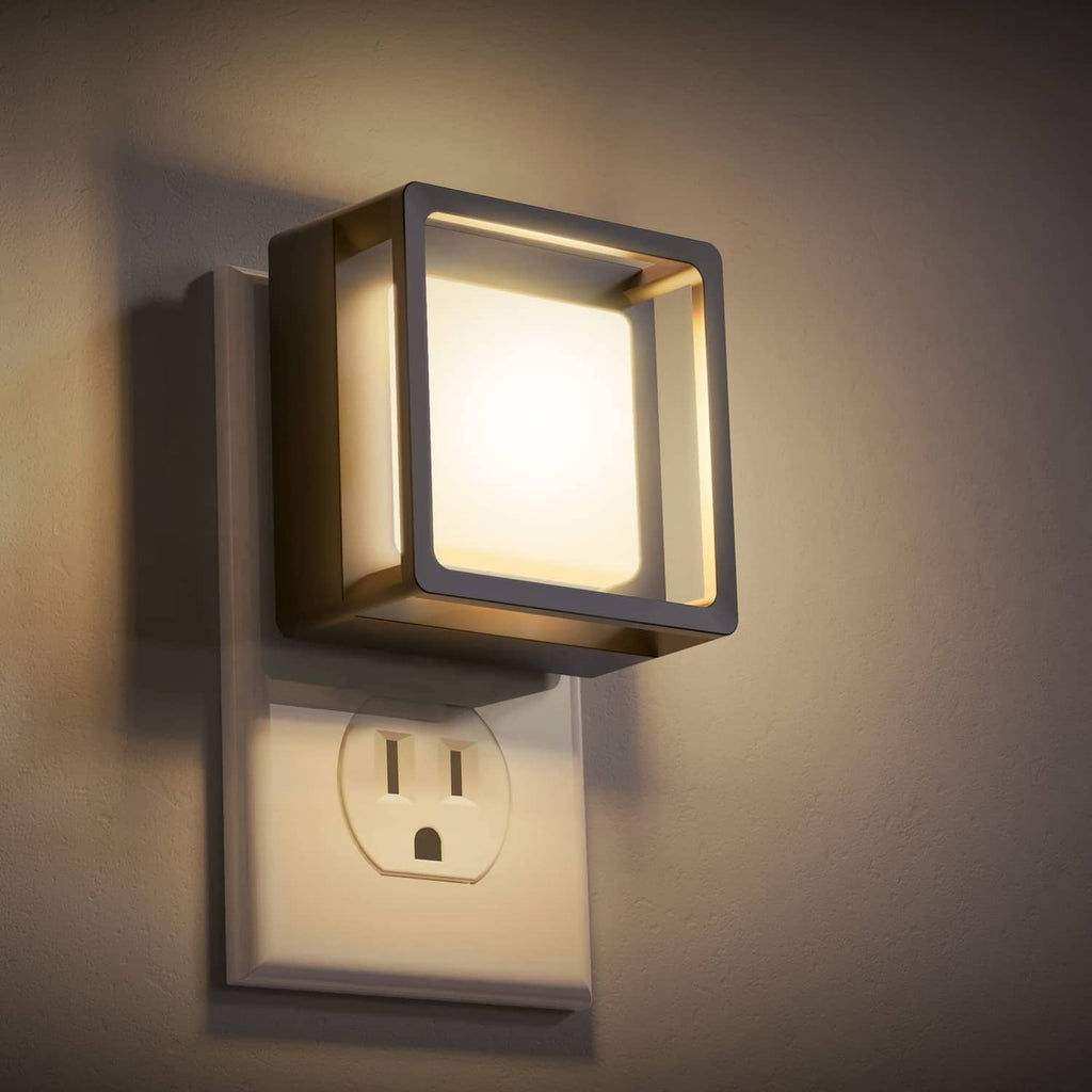 Plug-in LED night light with square dark frame and glowing white front panel