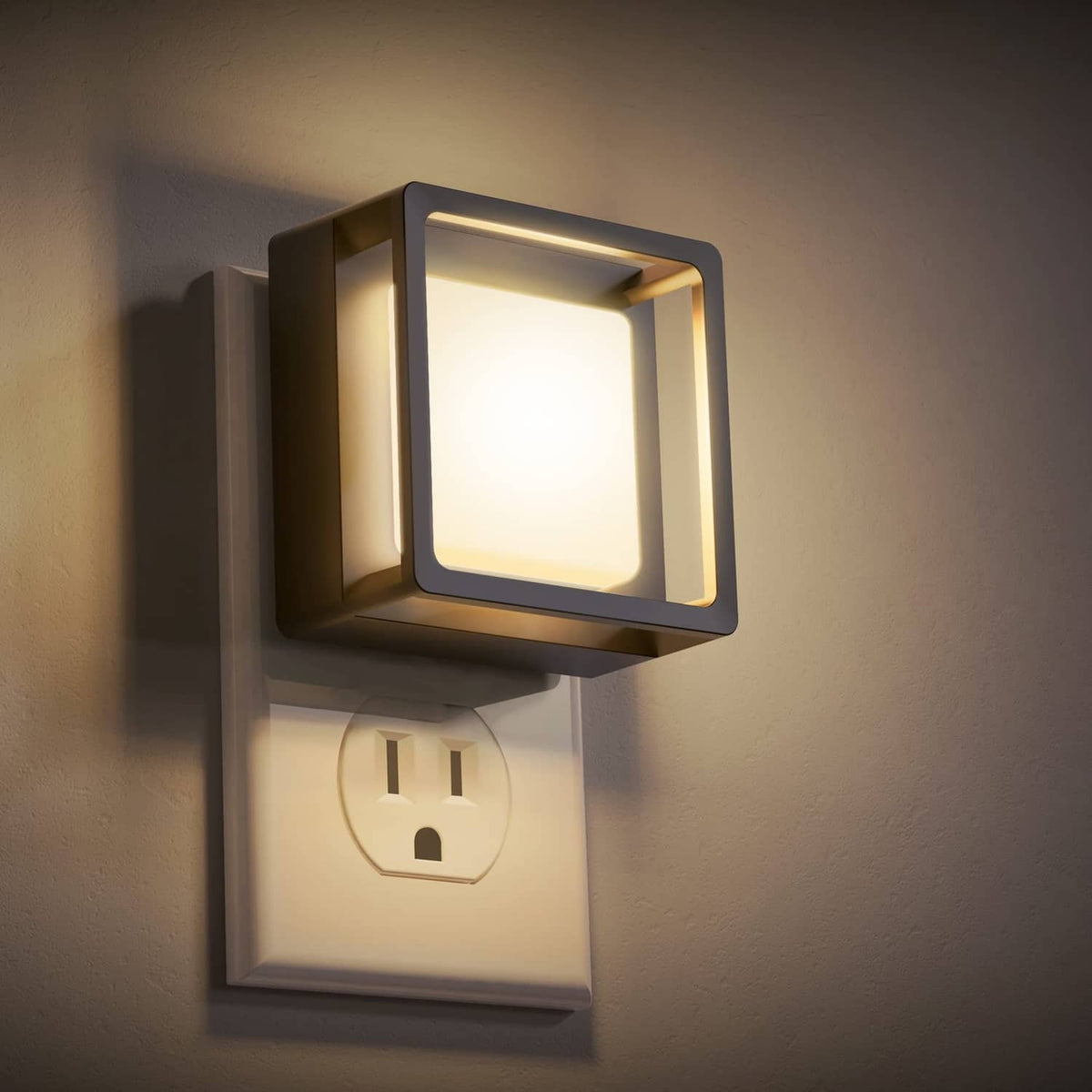 Plug-in LED night light with square dark frame and glowing white front panel