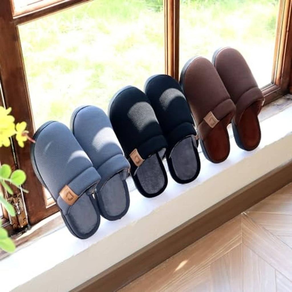 Set of slippers on a windowsill, blue and brown with dark gray slip-on style