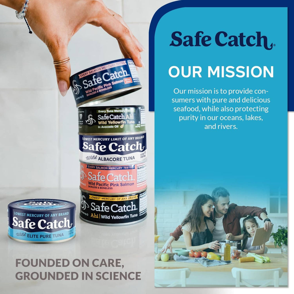 Hands stacking Safe Catch wild albacore tuna cans with blue-and-white labels.