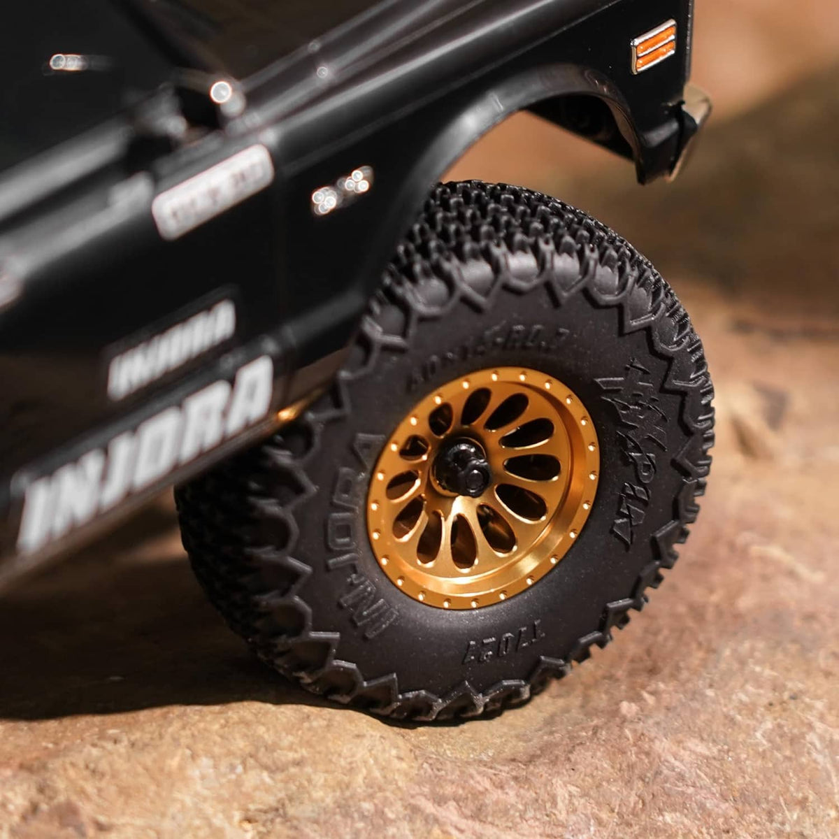 RC truck wheel with gold beadlock rim and black knobby tire