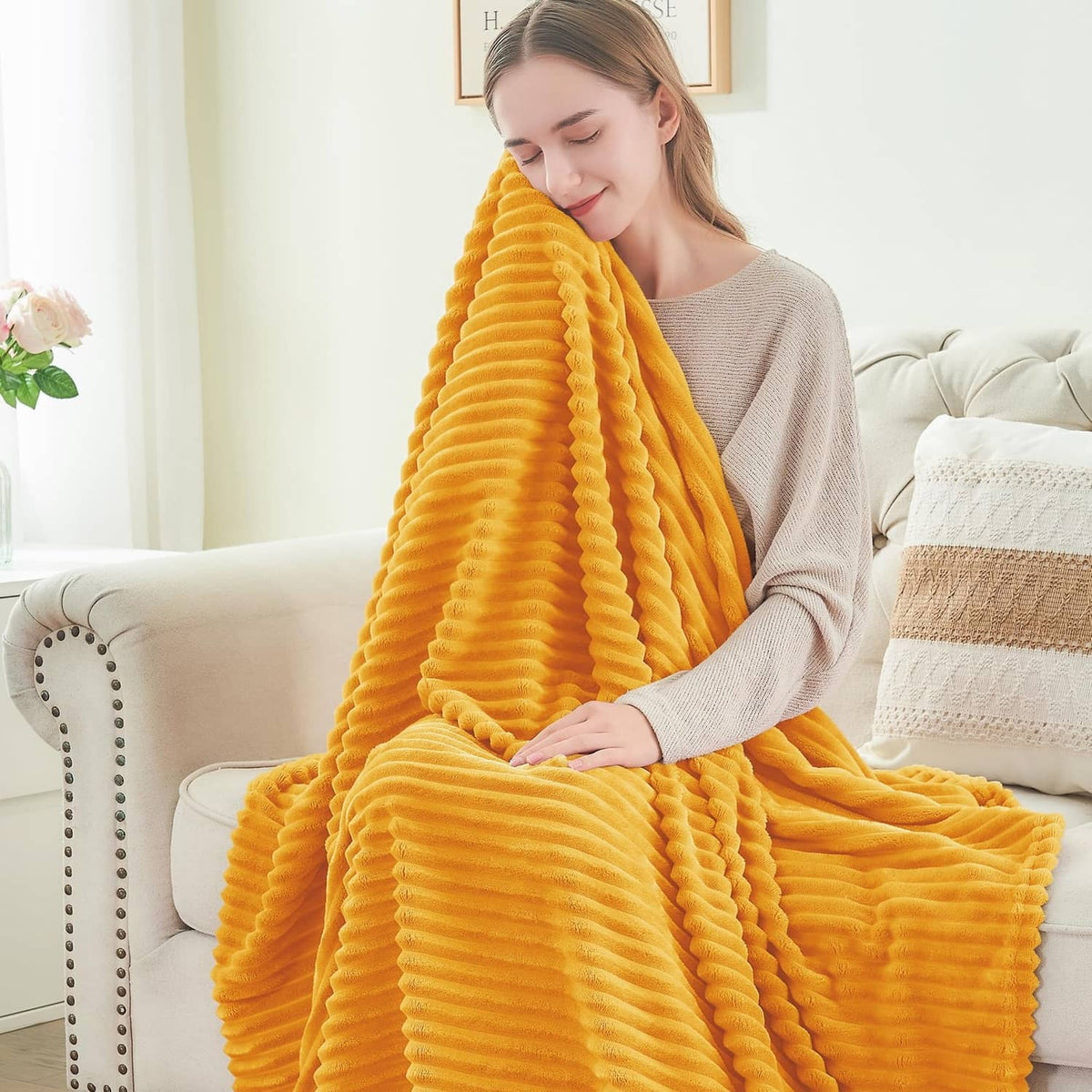 Yellow fleece throw blanket with 3D ribbed jacquard ridges, held over sofa