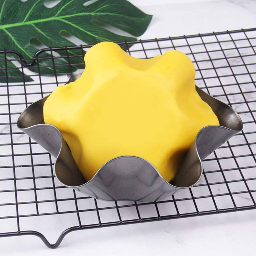 Black nonstick taco salad bowl mold on a wire rack, filled with yellow dough