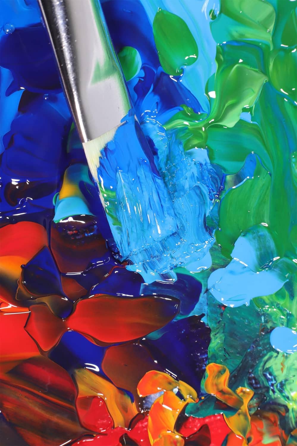 Close-up of acrylic paint with vivid blue and green strokes and thick texture