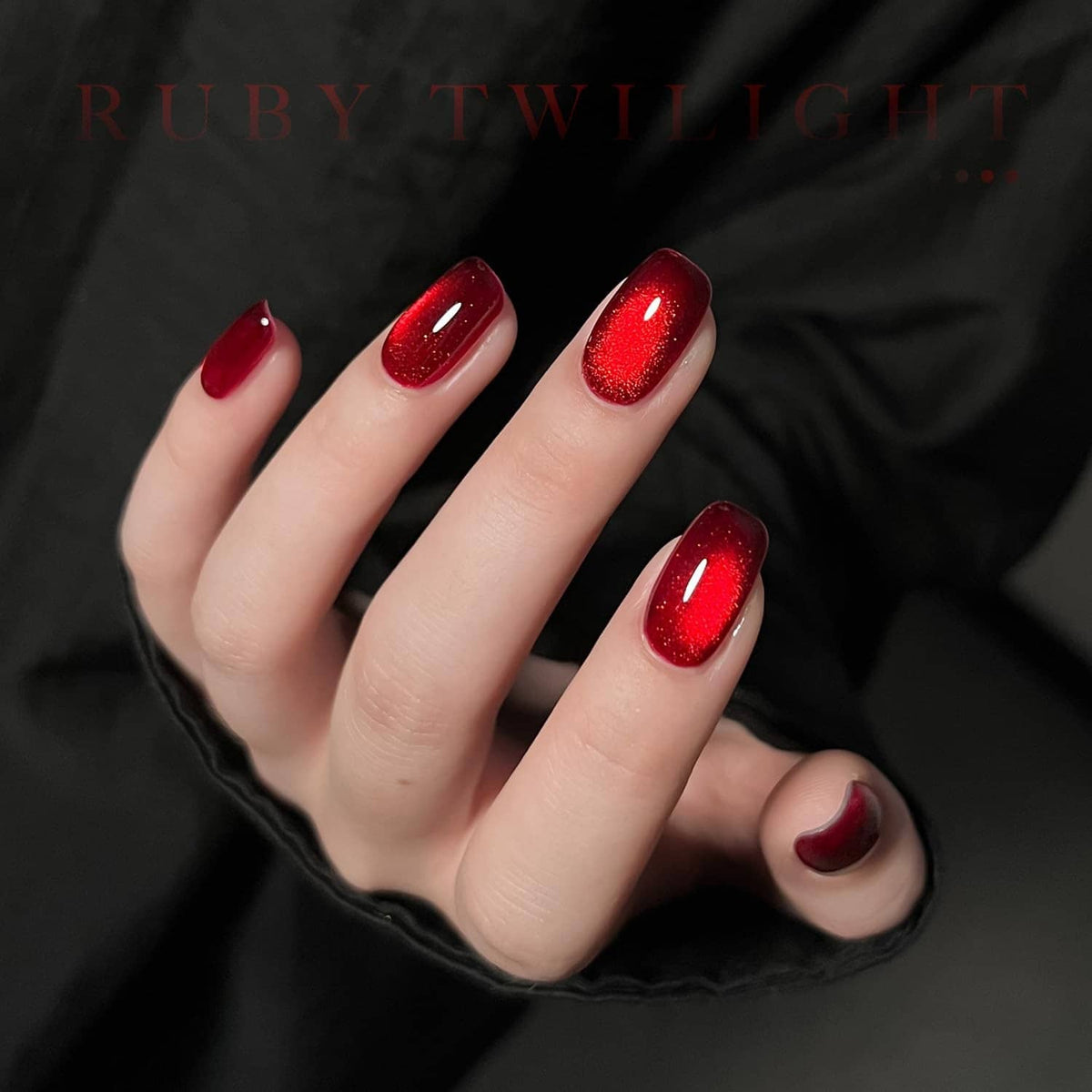 Dark red cat-eye gel nail polish on five nails with glowing shimmer.