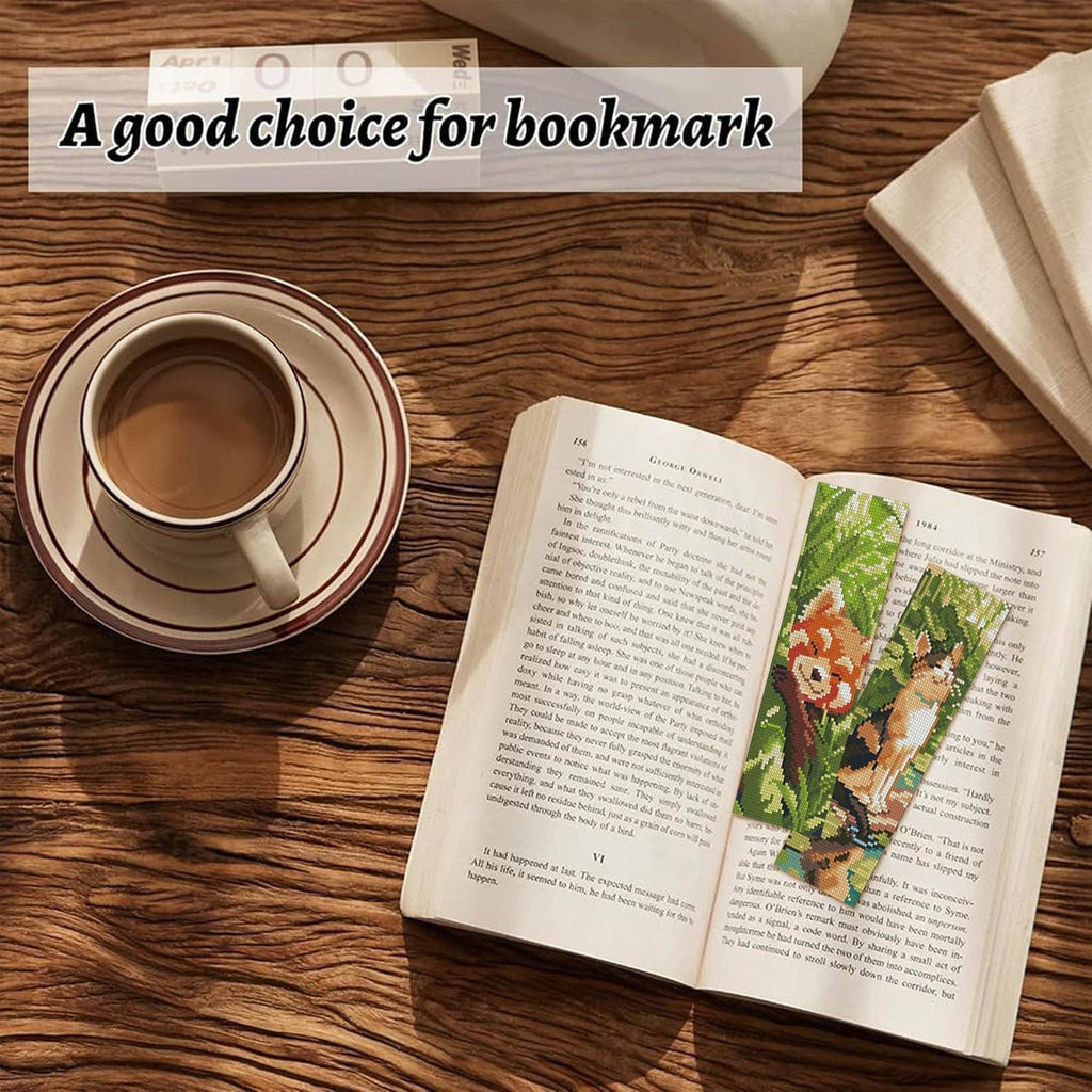 Animal cross-stitch bookmark in a book, shown on a stitched green pattern strip