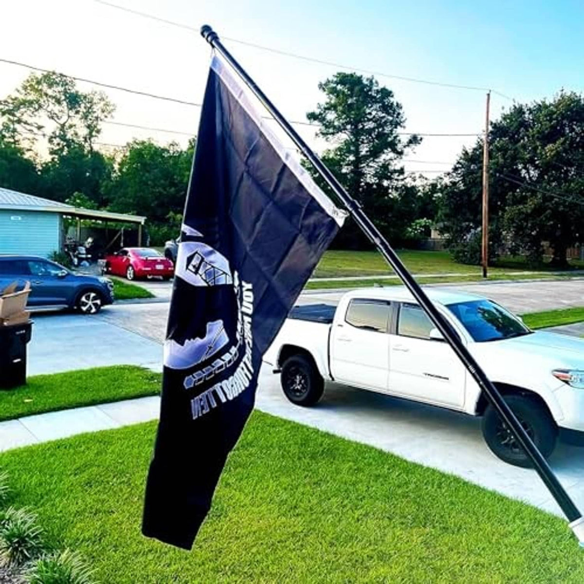 Black POW-MIA flag hanging vertically from an outdoor flag pole
