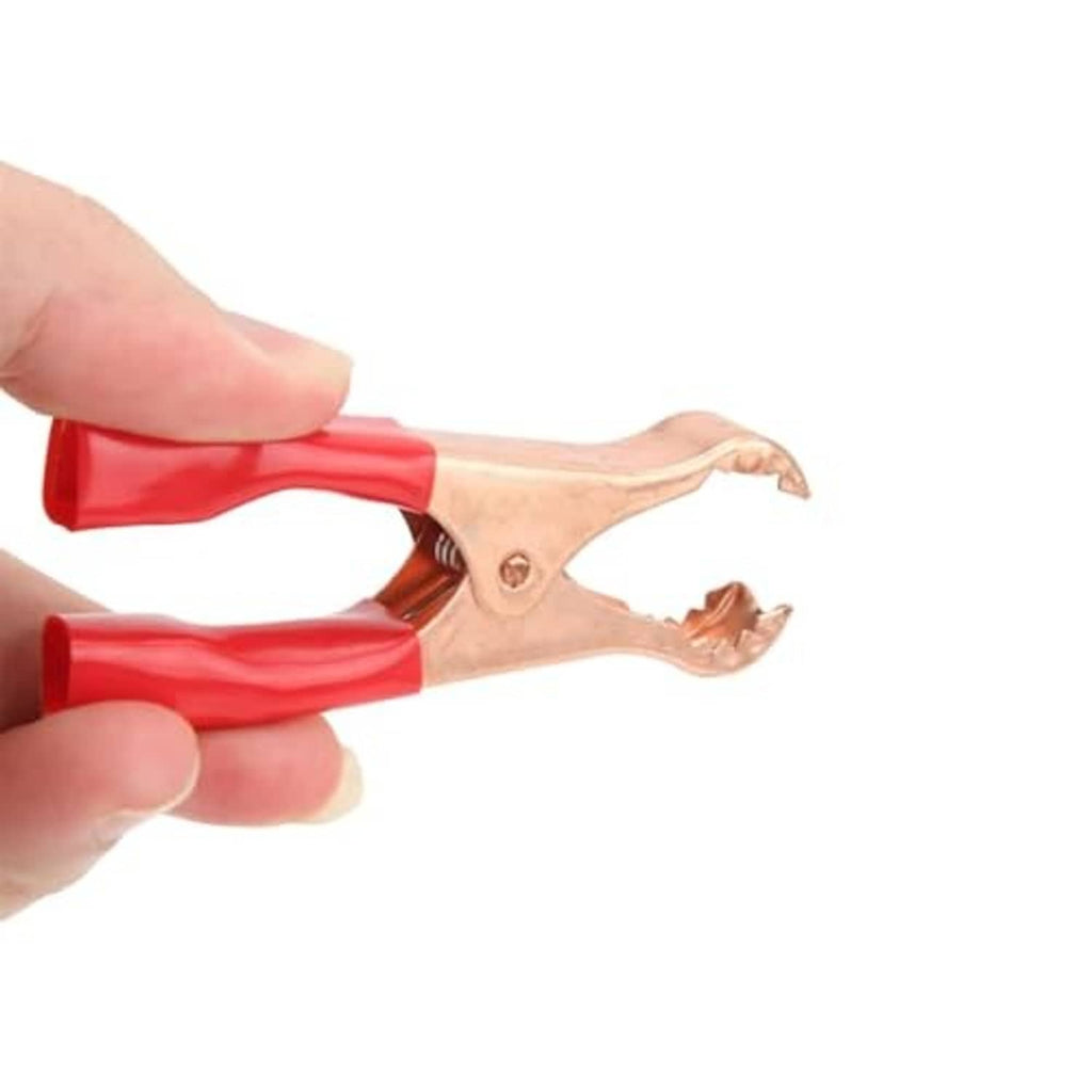 Insulated alligator clip close-up, copper jaws gripping; red insulated handle